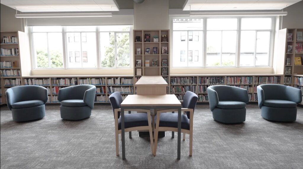 Library at the International School of San Francisco with window seating, armchairs and a reading table